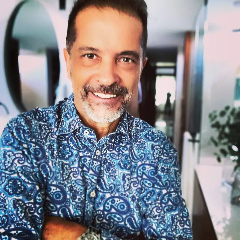 Retrato de Sergio Lubezky sonriendo, con camisa azul estampada