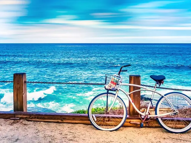 Bicicleta recargada en una baranda frente al mar turquesa